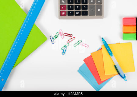 office, school, business, education and technology concept - close up of notebook, paper stickers, pencil, clip, calculator, different stuff on white  Stock Photo