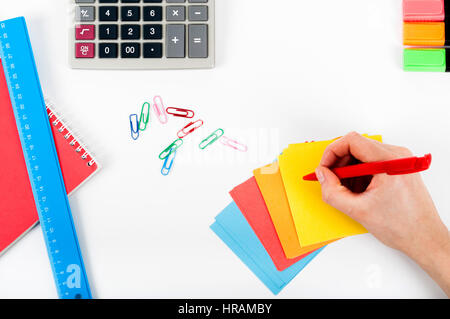 office, school, business, education and technology concept - close up of notebook, paper stickers, pencil, clip, calculator, different stuff on white  Stock Photo