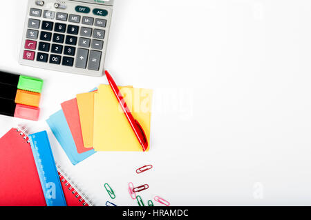office, school, business, education and technology concept - close up of notebook, paper stickers, pencil, clip, calculator, different stuff on white  Stock Photo