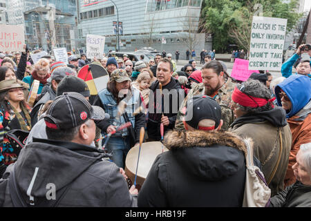 Vancouver, Canada. 28th Feb, 2017. Members of the Musqueam First Nations Band, singing a native songs at the opening of the Trump international Hotel, which attracted a few hundred anti-Trump protesters unhappy with the 'Trump' name being associated with the City of Vancouver. Trump International Hotel. Credit: Gerry Rousseau/Alamy Live News Stock Photo