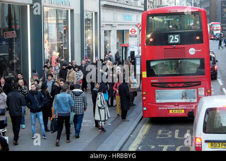 Red double decker number 25 bus, pedestrians and shoppers waiting at a bus stop on Oxford Street in West End shopping area of London UK  KATHY DEWITT Stock Photo