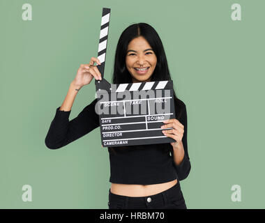 Young woman in croptop holding clapperboard Stock Photo