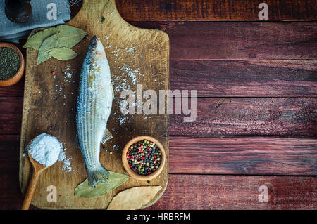Fresh fish smelt spices for cooking on a kitchen board, top view Stock Photo