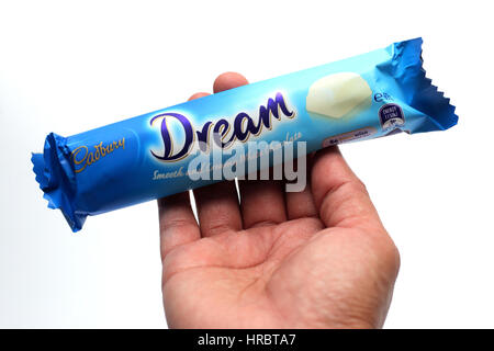 Hand holding Australia Cadbury white chocolate bar isolated against white background Stock Photo