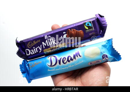 Hand holding Australia Cadbury white chocolate bar isolated against white background Stock Photo