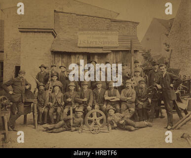 1893 antique industrial occupational photo of J.S.Kern of Scwiebus agricultural machine shop and foundry workers with iron gears, cogs, cogwheels, machinery and tools. Notice the young workers and the year written on one of the hammers. Source: cabinet photo discovered in Germany. Stock Photo