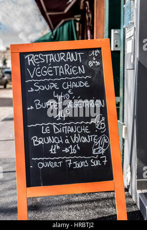 A french bistro menu sign on a blackboard written in white chalk on an orange stand.Found in Paris France. Stock Photo