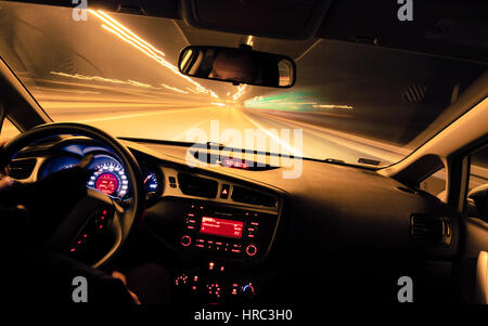 Night driving, view from inside car, city and other cars light is motion blurred. Stock Photo