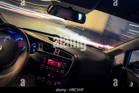 Night driving, view from inside car, city and other cars light is motion blurred. Stock Photo