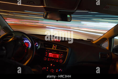 Night driving, view from inside car, city and other cars light is motion blurred. Stock Photo