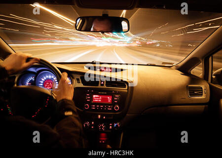 Night driving, view from inside car, city and other cars light is motion blurred. Stock Photo