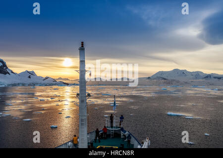 People on the ship's deck watching the sunset view among icebergs drifting at Lemaire Channel, Antarctica Stock Photo