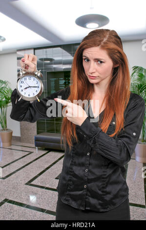 Woman counting the time on an alarm clock Stock Photo