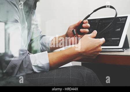 business man using VOIP headset with digital tablet computer docking smart keyboard, concept communication, it support,on wood desk Stock Photo