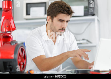 handsome engineer researching manufacturing issues with vacuum cleaner Stock Photo