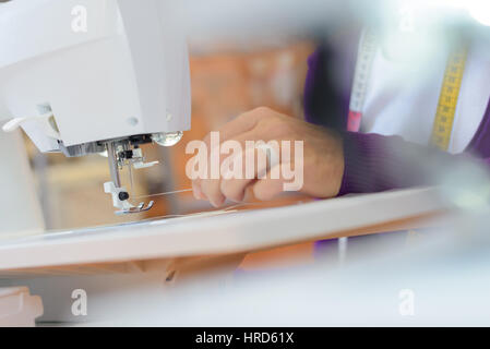 Closeup of woman threading needle on sewing machine Stock Photo
