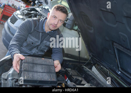 mechanic changing car air filter Stock Photo