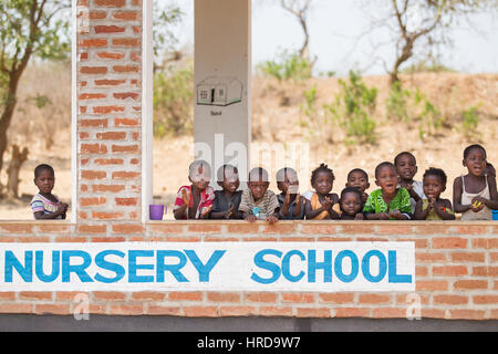 Young Malawian children go to school in a building donated by projects from the local wildlife reserve, Majete. The rural village borders the park. Stock Photo