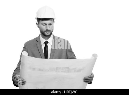 He is a planner. Professional male engineer studying a blueprint isolated on white copyspace monochrome shot professionalism experience architects bui Stock Photo