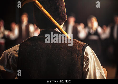 Details of dancer's back and hat holding a stick, dressed in traditional Serbian dress. Stock Photo