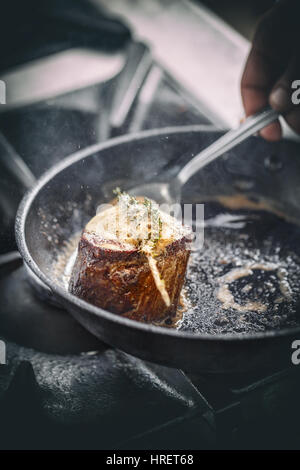 Beef steak fried in pan in restaurant kitchen Stock Photo