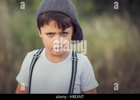 closeup of angry little boy with hat Stock Photo