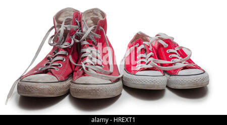 two pairs of old and new red basketball sneakers isolated on white background Stock Photo