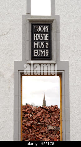 John Hastie Museum under construction, Looking Through the Doorway to a pile of bricks in the building with church steeple in the background Stock Photo