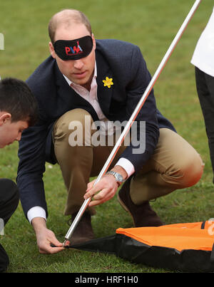 A blindfolded Duke of Cambridge playing with schoolchilren at Llanfoist Fawr Primary School in Abergavenny, Wales, where he officially launched the SkillForce Prince William Award encouraging children to develop good character, confidence and resilience. Stock Photo