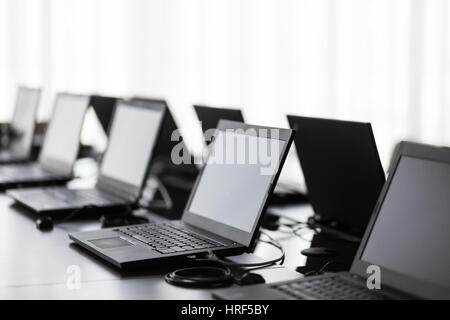 Modern conference room with furniture, laptops, big windows. office or training center interior. Computer Lab Stock Photo