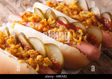 Danish food: hot dogs with crispy onions and pickled cucumbers close-up on the table. horizontal Stock Photo