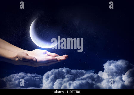 Human hand holding moon planet in palm Stock Photo
