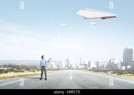 Elegant businessman and big paper plane flying in sky. Mixed media Stock Photo