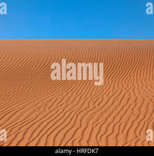 Wavy rippled desert or beach sand texture and blue sky Stock Photo