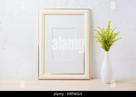 Gold decorated frame mockup with ornamental grass in exquisite vase. Empty frame mock up for presentation artwork. Stock Photo