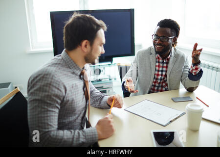 Two male financial managers in checked shirts sitting in modern office and preparing annual accounting reports Stock Photo