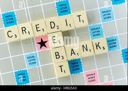 Words Credit, Debt and Bank spelt out on a Scrabble board as a financial or banking concept. Stock Photo