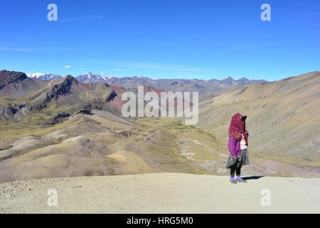 Unidentified peruvian woman on the Cerro Colorado - aka Rainbow Mountain, Vinicunca or Ausangate - in the region of Cusco, Peru Stock Photo