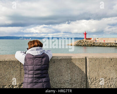 Bangor, Northern, Ireland. 1st March, 2017. UK weather: A woman looks out to Belfast Lough as Bangor enjoyed a generally sunny day although the temperature only reached around 8C. Rain is forecast for this evening with the temperature dropping to 4C. Credit: J Orr/Alamy Live News Stock Photo