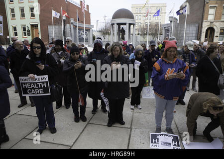 Trenton, New Jersey, USA. 27th Feb, 2017. Demonstrators are shown using their cell phones calling Gov., Chris Christie, R-N.J. to oppose any proposed Republican plan to repeal the Affordable Cares Act during a health care rally on the steps of the Statehouse in Trenton, New Jersey. 'Demonstrators said the governor's line was busy. Credit: Brian Branch Price/ZUMA Wire/Alamy Live News Stock Photo