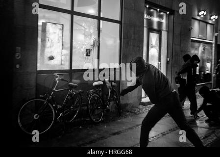 Denmark, Copenhagen, March 1st. 2017. Left wing activists took the streets of Copenhagen ten years after the demolition of the Ungdomshuset youth house at Jagtvej 69. Under the statement “The fight continues, nothing forgotten, nothing forgiven” the activists clashed with the police during the march. Here the activists attack a bank with stones. Credit: Gonzales Photo/Alamy Live News Stock Photo