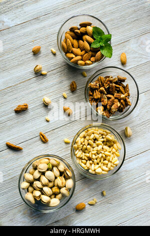 Healthy snacks of nuts in ramekins on a wood table Stock Photo