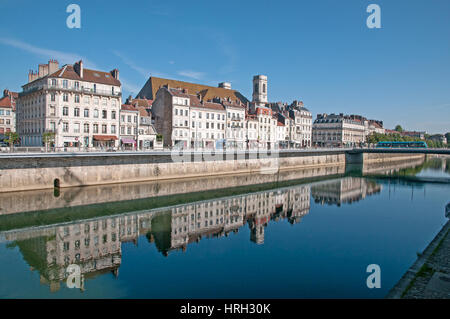 Buildings along river Doubs on Quai Veil Picard in Besancon with Church Eglise Sainte Madeleine in background Tram crossing Pont Battant on right Stock Photo