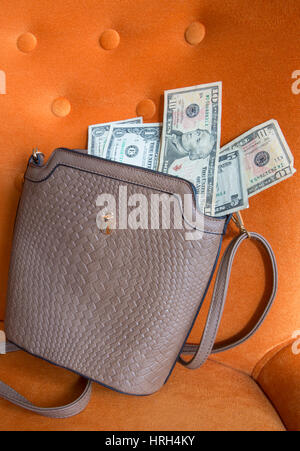 Dollar bills on top of a handbag. Stock Photo