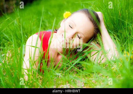 Model released, Junge Frau liegt entspannt in Fruehlingswiese - woman relaxing in a spring meadow Stock Photo