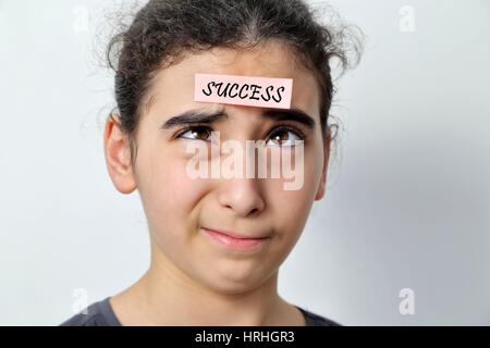 Little girl with memo posts on her forehead, with motivational message Stock Photo