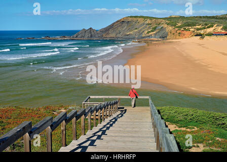 Wooden steps and view point with woman looking to natural beach Stock Photo