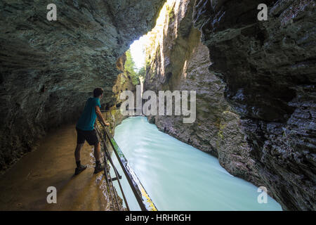 Hiker on walkways admires the creek in the narrow limestone gorge, Aare Gorge, Bernese Oberland, Canton of Uri, Switzerland Stock Photo