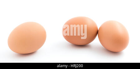 Two upright chicken eggs and one laying sideways isolated on white. Stock Photo
