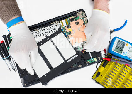 Repair of the  modern notebook computer in the professional service center. Repair man uses the ESD antistatic equipment. No brands or logos - only st Stock Photo